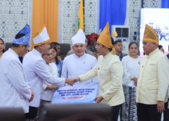 Bantuan dari pemerintah Kabupaten Kepulauan Sangihe diserahkan secara simbolis kepada perwakilan Pemkab Sitaro. (Foto: Ist)