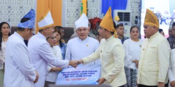 Bantuan dari pemerintah Kabupaten Kepulauan Sangihe diserahkan secara simbolis kepada perwakilan Pemkab Sitaro. (Foto: Ist)