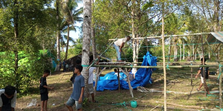 Potret rombongan pemuda GMPU dari Kabupaten Kepualaun Sangihe sedang menyelesaikan pembuatan tenda.