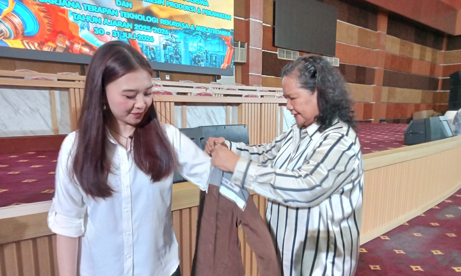 Direktur Polimdo, Dra Maryke Alelo, MBA memberikan penyematan kameja PKL kepada Christyvena Rau. (foto : Meikel/Barta)