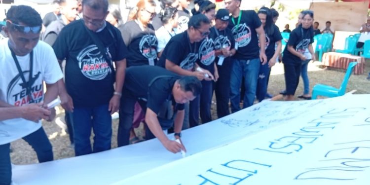 Puluhan aktivis menorehkan komitmen mereka menandatangani seruan untuk menuntaskan persoalan tata ruang dan lingkungan dalam Temu Rakyat Sulut di Desa Kalasey 2 baru-baru. (foto: Barta1)