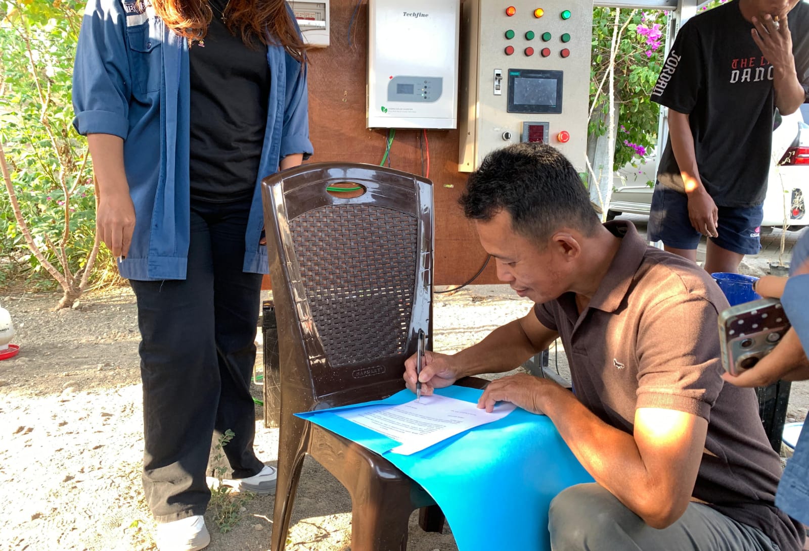Mitra Rinaldi Mapalle menandatangani dokumen menerima alat pengelola pakan hasil penelitian mahasiswa Jurusan Teknik Elektro Polimdo. (foto : istimewa)