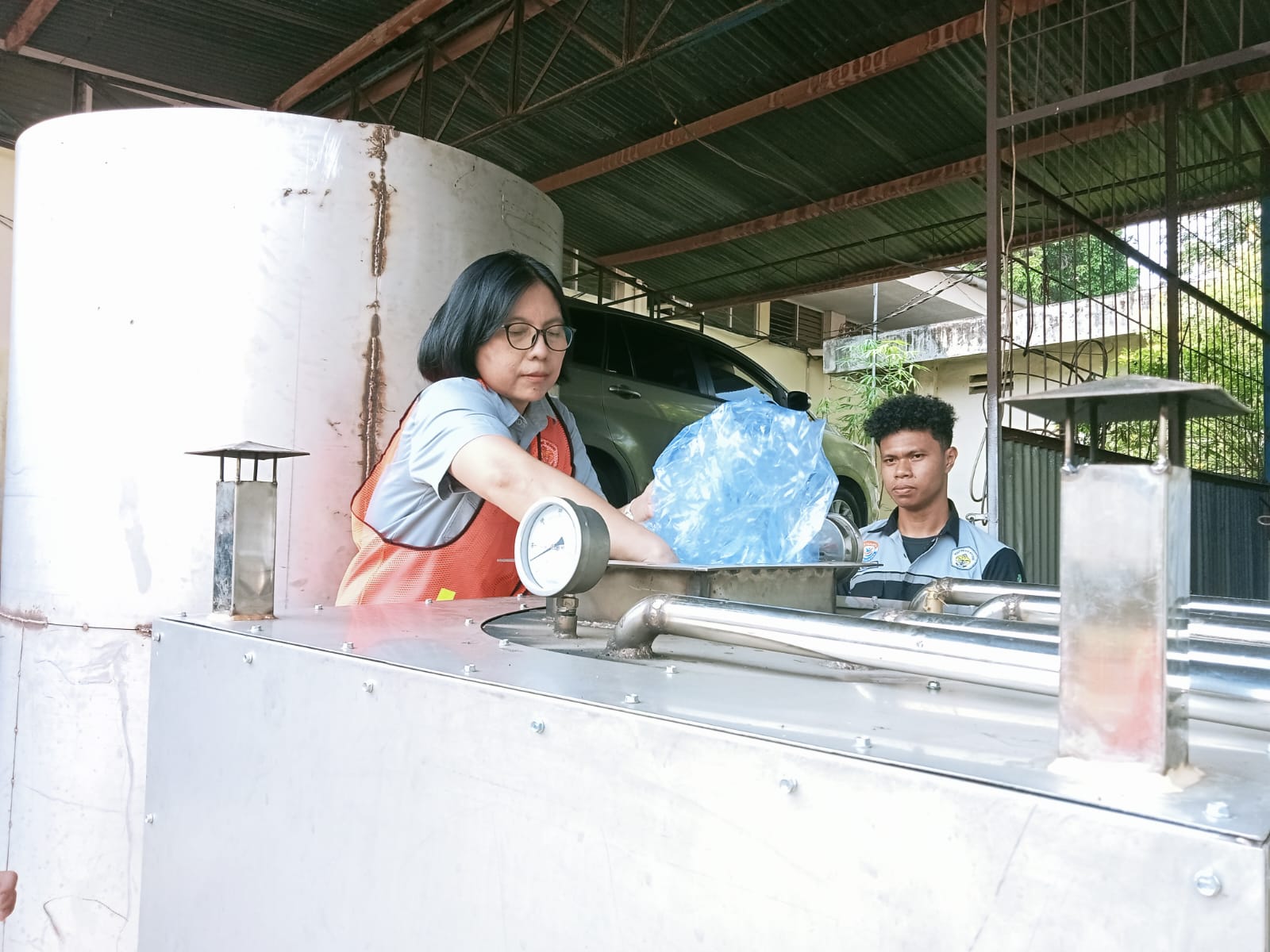 Tim peneliti KONEKSI, Dr. Wanda Sanni Slat, SST., M.Eng saat mendemonstrasikan alat dalam pengelolaan sampah plastik menjadi bahan bakar. (foto : Meikel /Barta) 